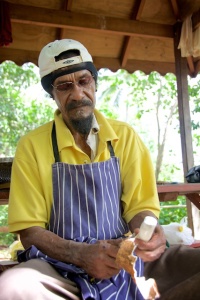 Caribe Indian cutting the cassava root to make bread